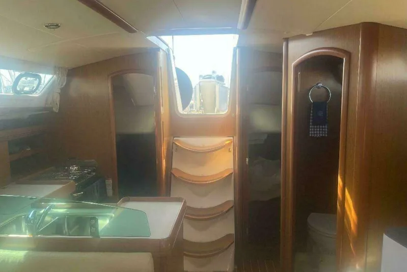 Phantom Yacht Photos Pics Interior of 2007 Jeanneau Sun Odyssey 39i sailboat with wood finish and compact kitchen.