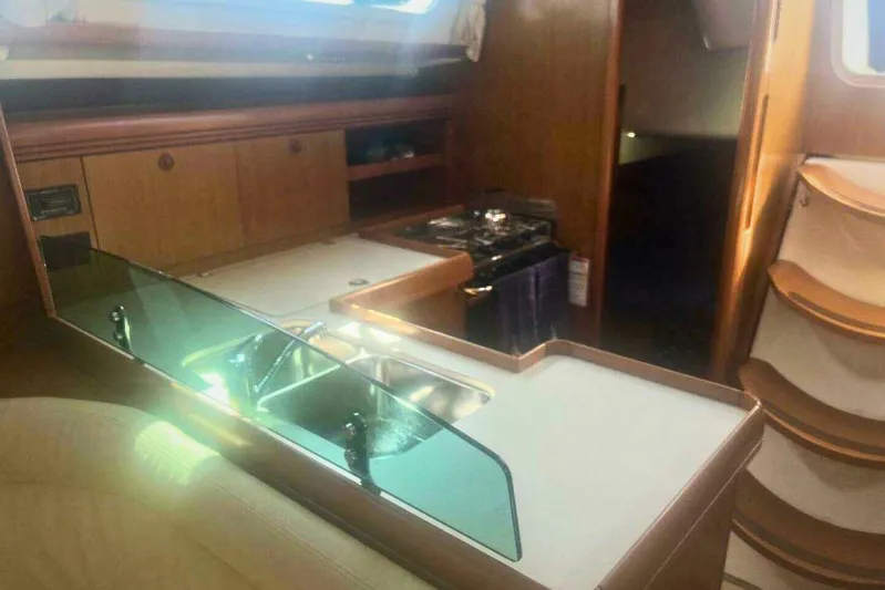 Phantom Yacht Photos Pics Interior of 2007 Jeanneau Sun Odyssey 39i yacht with kitchen and wooden cabinetry.