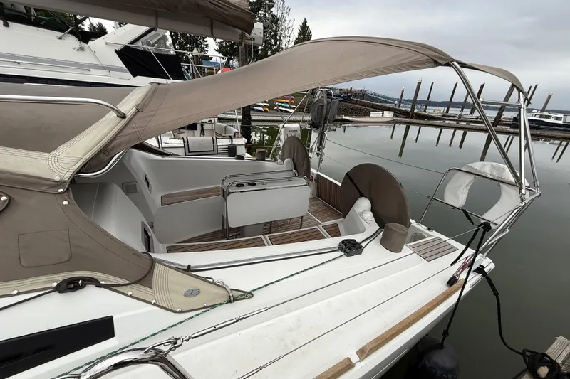 A Bientot Yacht Photos Pics 2016 Jeanneau Sun Odyssey 349 sailboat docked at marina, featuring spacious cockpit and canopy.