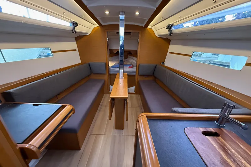 A Bientot Yacht Photos Pics Interior of 2016 Jeanneau Sun Odyssey 349 sailboat, featuring cozy seating and modern design.