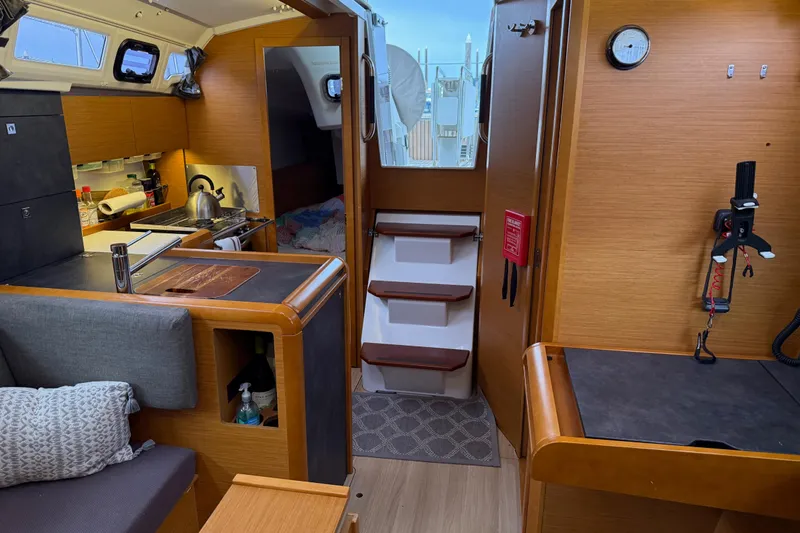 A Bientot Yacht Photos Pics Interior of 2016 Jeanneau Sun Odyssey 349 sailboat, featuring cozy kitchen and seating area.