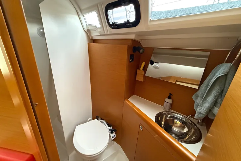 A Bientot Yacht Photos Pics 2016 Jeanneau Sun Odyssey 349 bathroom with modern fixtures and wooden cabinetry.