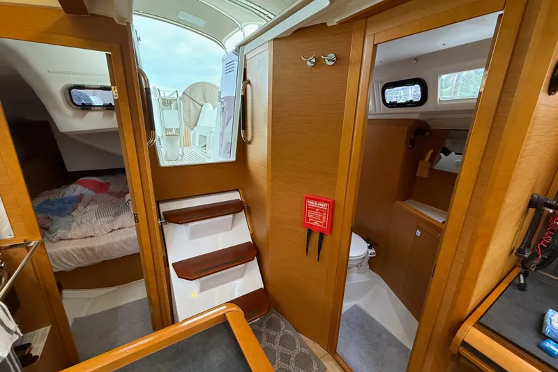 A Bientot Yacht Photos Pics Interior of 2016 Jeanneau Sun Odyssey 349 sailboat, featuring cabin, stairs, and bathroom.