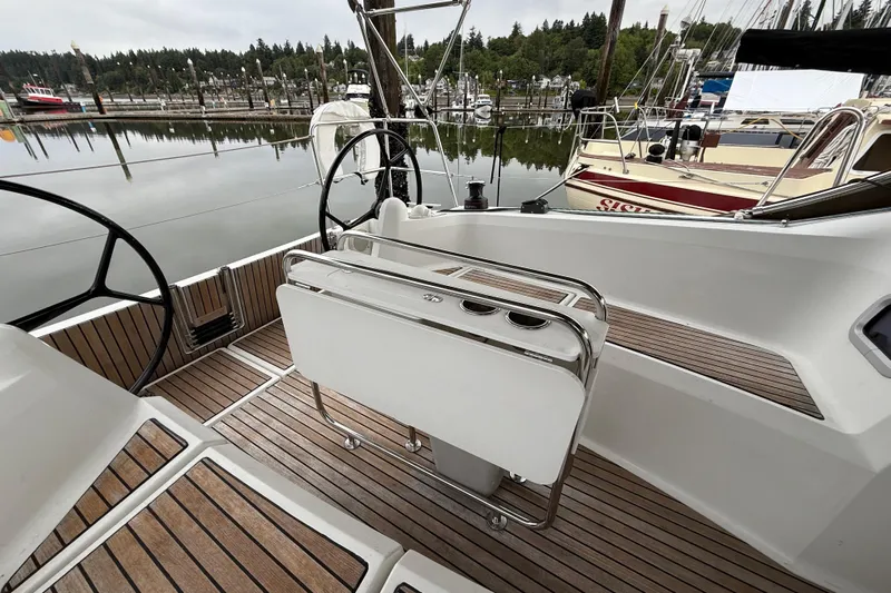 A Bientot Yacht Photos Pics 2016 Jeanneau Sun Odyssey 349 sailboat cockpit with dual steering wheels, docked in a marina.