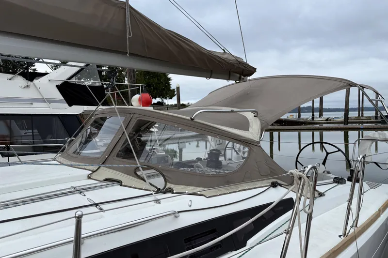 A Bientot Yacht Photos Pics 2016 Jeanneau Sun Odyssey 349 sailboat docked, featuring a sleek design and beige canopy.