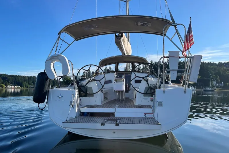 A Bientot Yacht Photos Pics 2016 Jeanneau Sun Odyssey 349 sailboat with dual steering wheels, docked on calm water.