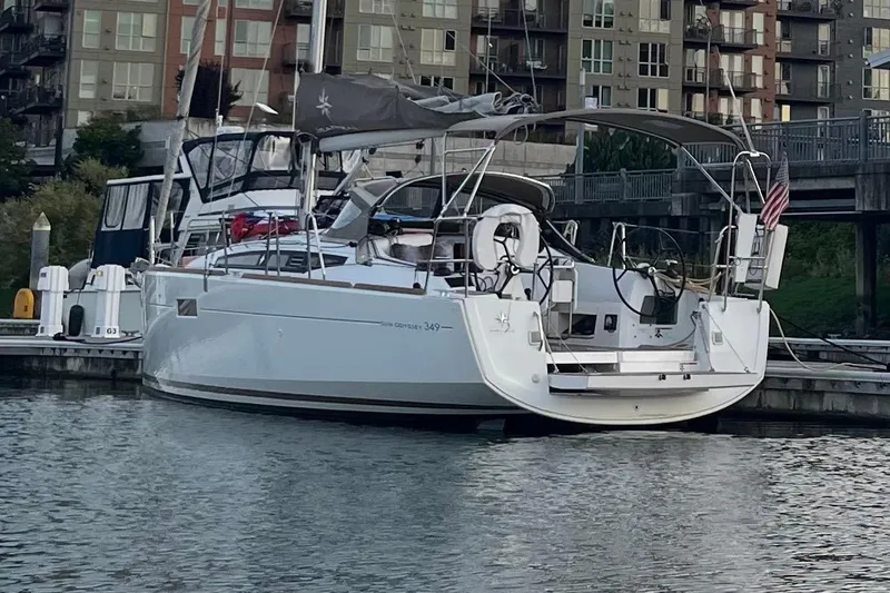 A Bientot Yacht Photos Pics 2016 Jeanneau Sun Odyssey 349 sailboat docked in marina, urban backdrop.