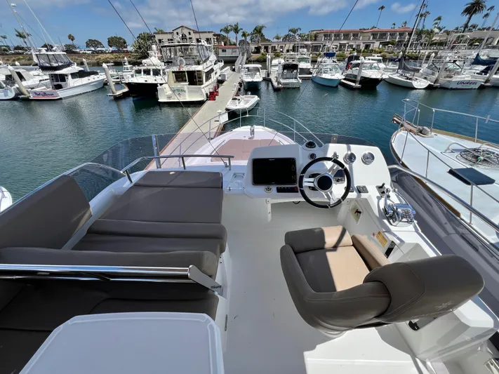  Yacht Photos Pics Flybridge of 2017 Jeanneau Velasco 43 yacht docked in a marina, featuring helm and seating area.