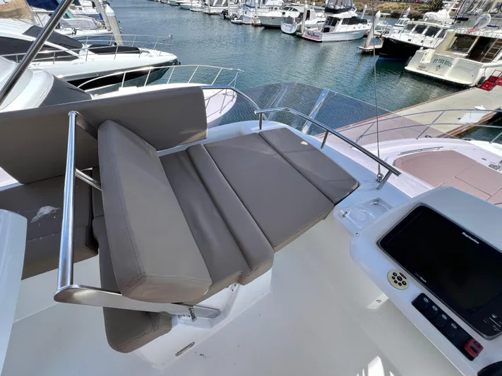  Yacht Photos Pics Flybridge seating on 2017 Jeanneau Velasco 43 yacht, overlooking marina with multiple boats.