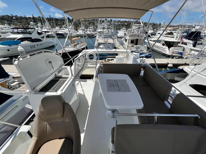  Yacht Photos Pics Flybridge of 2017 Jeanneau Velasco 43 yacht with seating and dining area in marina.