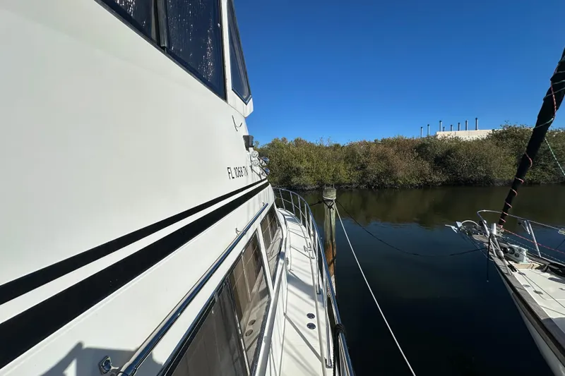  Yacht Photos Pics 2006 Novatec Islander 55 yacht docked by a calm river under clear blue skies.
