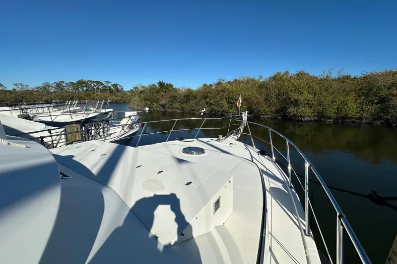  Yacht Photos Pics Novatec Islander 55 yacht, 2006 model, docked near lush greenery under clear blue sky.