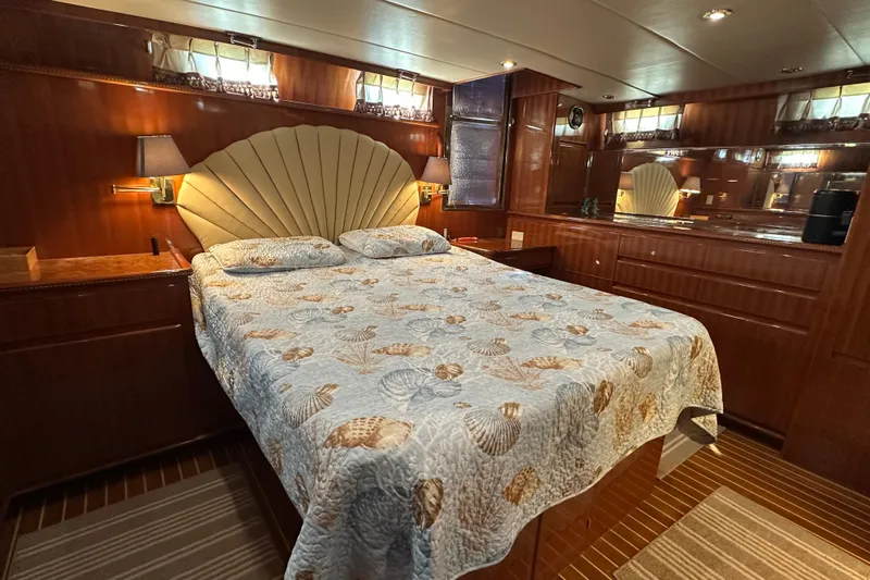  Yacht Photos Pics Luxurious bedroom in 2006 Novatec Islander 55 yacht with elegant wood paneling and seashell-themed bedding.