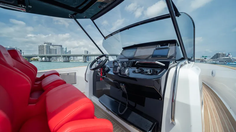 Freedom Yacht Photos Pics 2023 Pardo Yachts 38 helm with red seats, modern controls, and cityscape background.