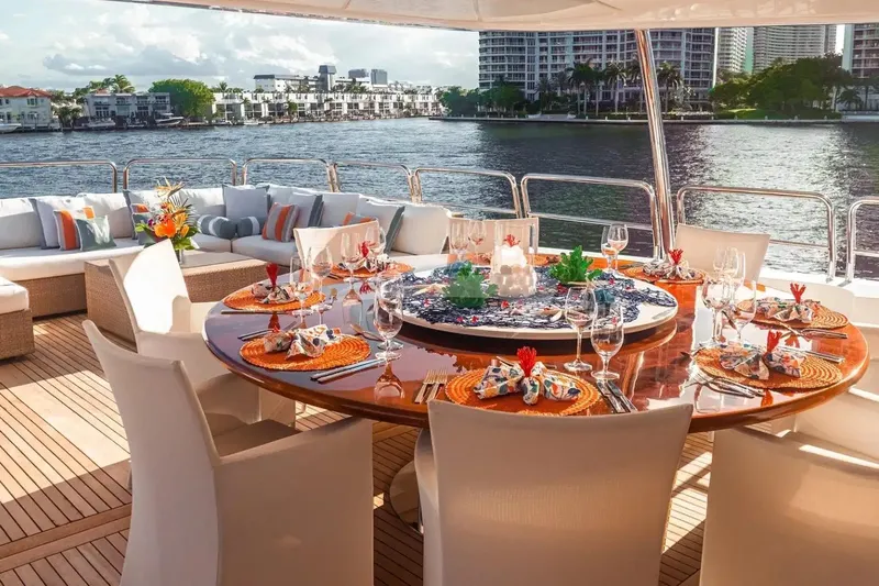 Mamma Mia Yacht Photos Pics Luxurious dining setup on 2007 Benetti 120 Classic yacht, overlooking waterfront cityscape.