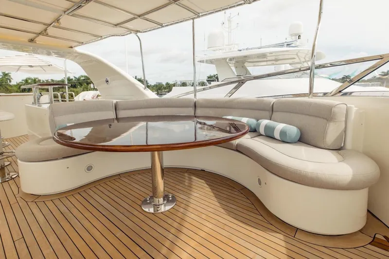 Mamma Mia Yacht Photos Pics Luxurious seating area on 2007 Benetti 120 Classic yacht with wooden table and cushions.