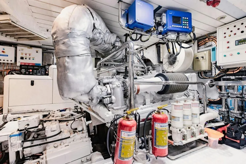 Mamma Mia Yacht Photos Pics Engine room of a 2007 Benetti 120 Classic yacht, featuring complex machinery and fire extinguishers.