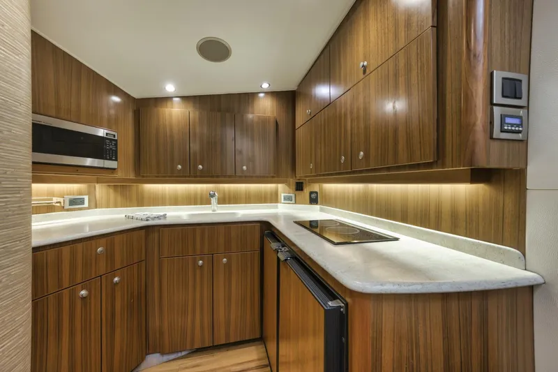 Blondie Yacht Photos Pics Modern kitchen interior of 2012 Viking 42 Open yacht with wood cabinetry and sleek countertops.