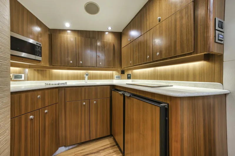 Blondie Yacht Photos Pics Luxurious wooden kitchen interior of 2012 Viking 42 Open yacht, featuring modern appliances.