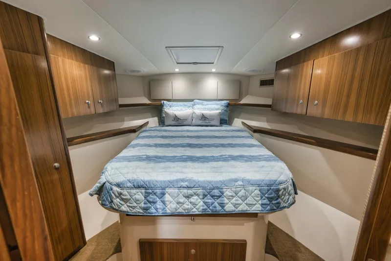 Blondie Yacht Photos Pics Luxurious cabin interior of 2012 Viking 42 Open yacht with cozy bed and wooden cabinetry.