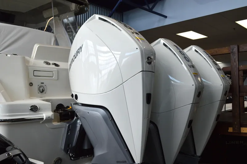  Yacht Photos Pics 2024 Boston Whaler 350 Realm with triple Mercury outboard engines in a showroom.