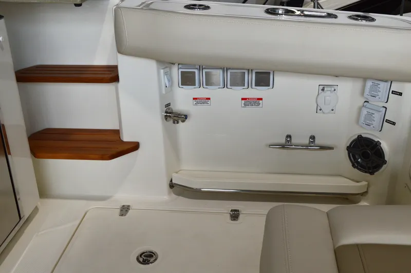  Yacht Photos Pics 2024 Boston Whaler 350 Realm interior with control panel and wooden steps.