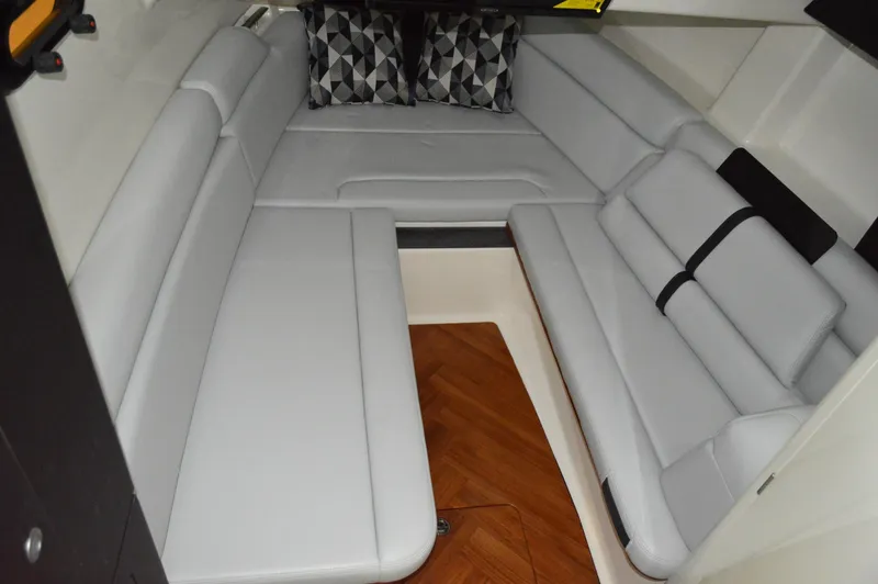  Yacht Photos Pics 2024 Boston Whaler 350 Realm interior cabin with gray seating and geometric pillows.