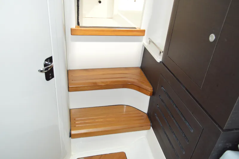  Yacht Photos Pics 2024 Boston Whaler 350 Realm interior with wooden steps and sleek cabinetry.