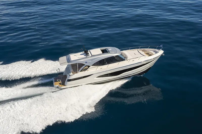  Yacht Photos Pics 2025 Riviera 4300 yacht cruising on open water, showcasing sleek design and performance.