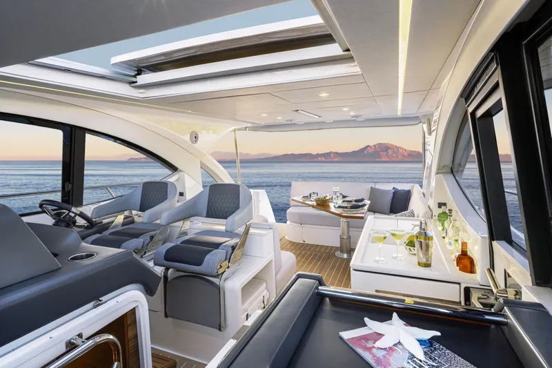  Yacht Photos Pics Luxurious 2025 Riviera 4300 yacht interior with ocean view, featuring elegant seating and dining area.