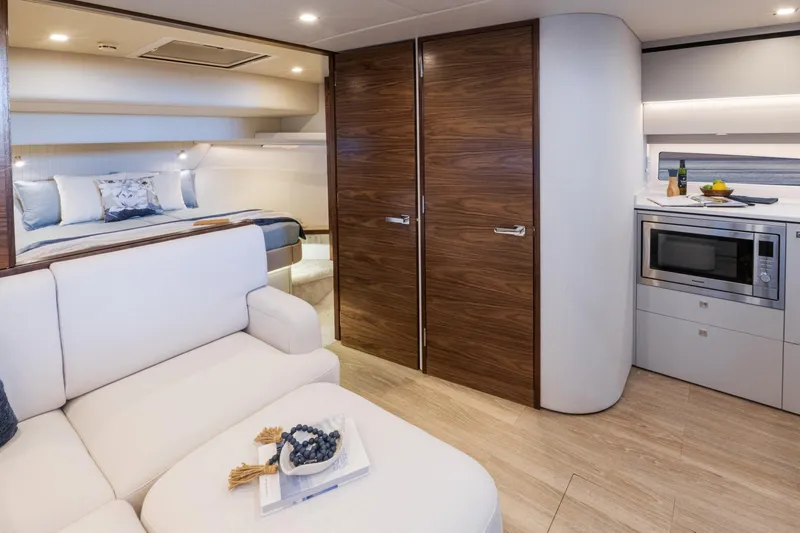  Yacht Photos Pics Luxurious interior of 2025 Riviera 4300 yacht with modern kitchen and cozy bedroom.