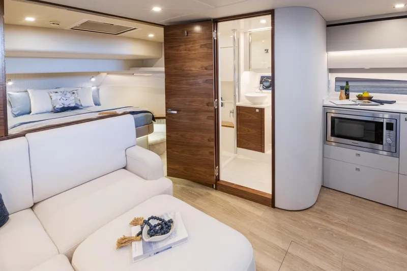  Yacht Photos Pics Luxurious interior of 2025 Riviera 4300 yacht featuring bedroom, kitchenette, and bathroom.