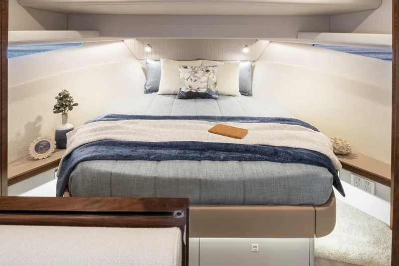  Yacht Photos Pics Luxurious 2025 Riviera 4300 yacht bedroom with cozy bedding and elegant decor.