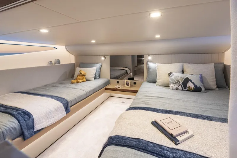  Yacht Photos Pics Luxurious 2025 Riviera 4300 yacht cabin with twin beds, plush pillows, and elegant decor.