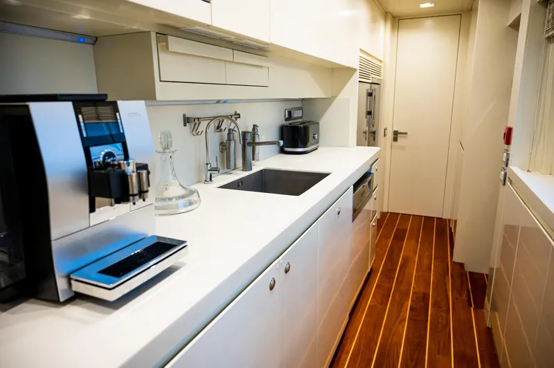  Yacht Photos Pics Modern yacht kitchen with sleek white cabinetry, wooden flooring, and stainless steel appliances. Benetti Sail Division 90, 2010.