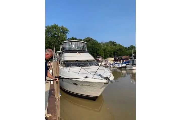 Why Knot Yacht Photos Pics 2001 Carver 396 Motor Yacht docked at a marina, surrounded by trees and boats.