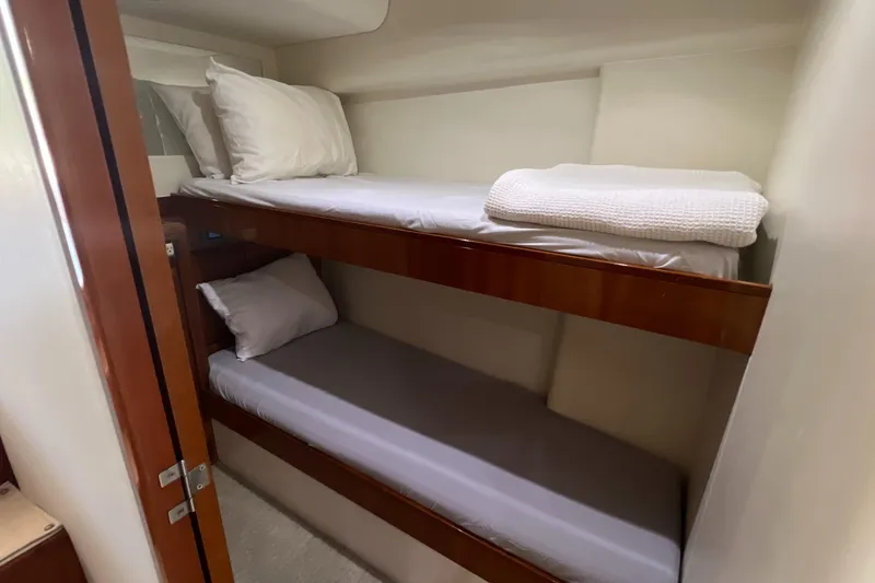 Dream On Yacht Photos Pics Bunk beds in 2005 Bertram 450 yacht cabin, featuring wooden frames and white bedding.