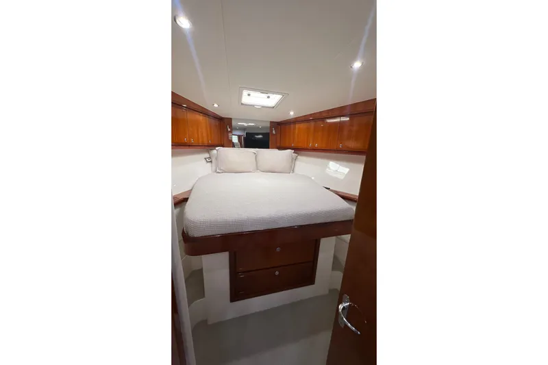 Dream On Yacht Photos Pics Interior of 2005 Bertram 450 yacht with cozy bed and wooden cabinets.