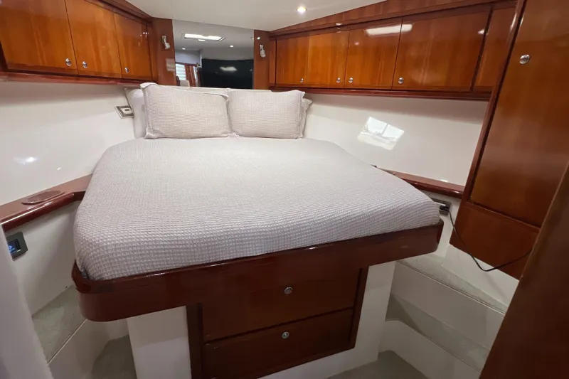 Dream On Yacht Photos Pics Luxurious cabin interior of a 2005 Bertram 450 yacht with wooden cabinetry and cozy bedding.