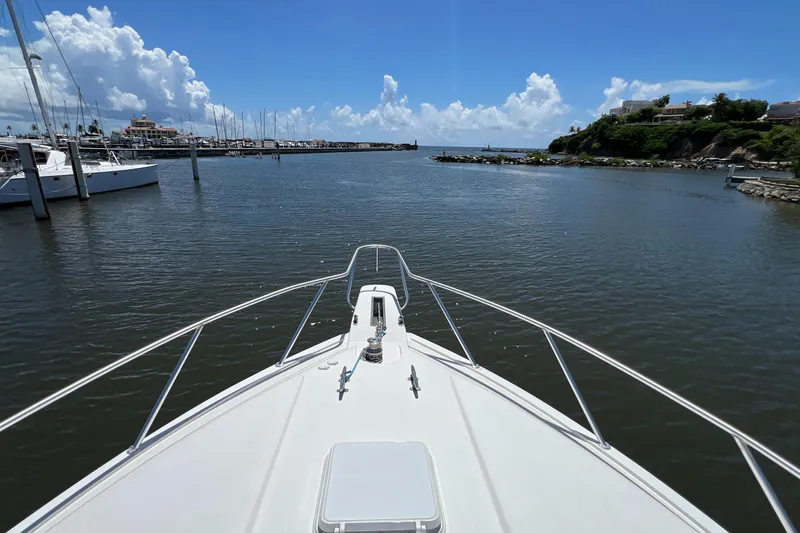 Dream On Yacht Photos Pics Bow view from a 2005 Bertram 450 yacht entering a marina under a clear blue sky.