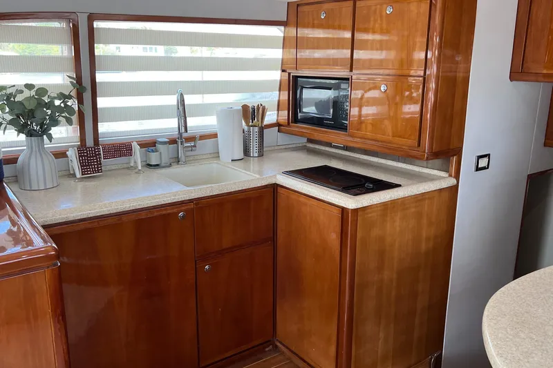 Dream On Yacht Photos Pics Luxurious kitchen interior of 2005 Bertram 450 yacht with wooden cabinets and modern appliances.