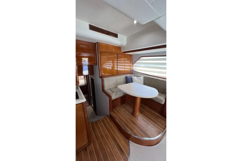 Dream On Yacht Photos Pics Interior of 2005 Bertram 450 yacht with wooden flooring and cozy dining area.
