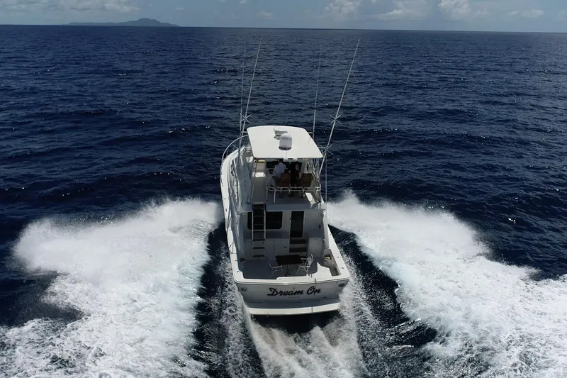 Dream On Yacht Photos Pics 2005 Bertram 450 yacht cruising on open ocean, creating a wake behind.