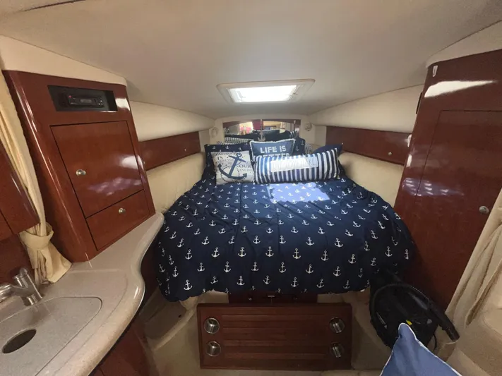  Yacht Photos Pics Interior cabin of 2006 Sea Ray 320 Sundancer with nautical-themed bedding and wood cabinetry.
