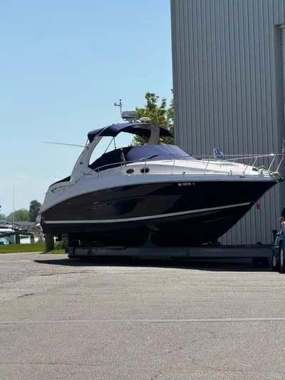  Yacht Photos Pics 2006 Sea Ray 320 Sundancer boat on trailer near a marina, sunny day.