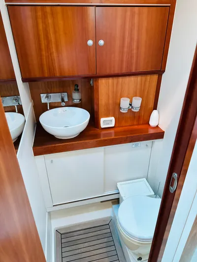  Yacht Photos Pics 2014 Hanse 575 yacht bathroom with wooden cabinets, sink, and toilet.