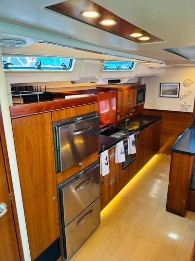  Yacht Photos Pics Modern kitchen in 2014 Hanse 575 yacht with wood cabinetry and stainless steel appliances.