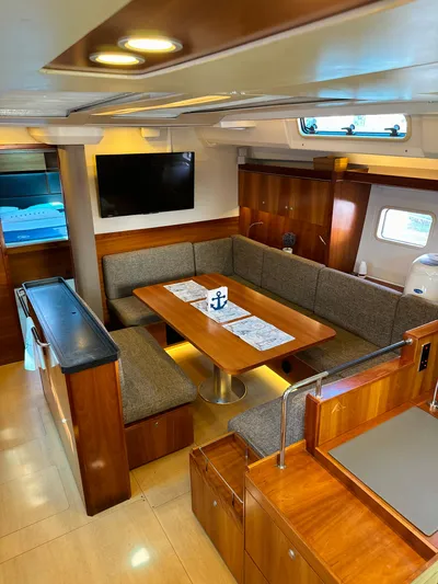  Yacht Photos Pics 2014 Hanse 575 yacht interior with dining area, TV, and wooden cabinetry.