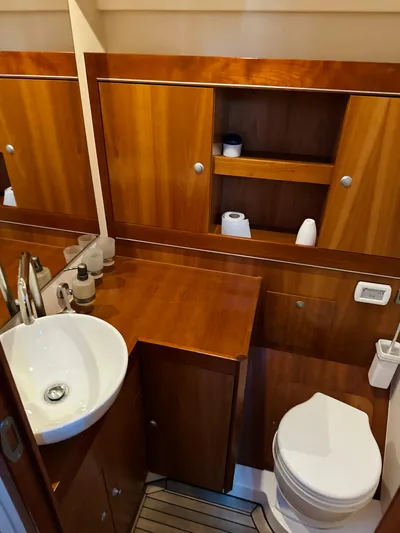  Yacht Photos Pics 2014 Hanse 575 yacht bathroom with wooden cabinetry and modern fixtures.