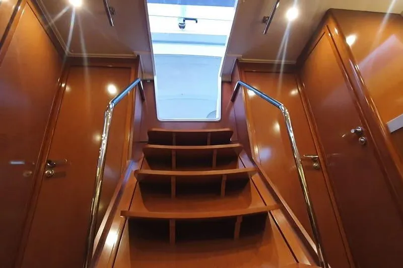 Mareo Yacht Photos Pics Interior view of 2018 Beneteau Oceanis 55.1 yacht with wooden stairs and sleek design.